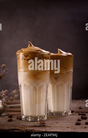 Café Dalgona. Boisson fouettée à glacer avec café instantané populaire en Corée cocktail crémeux dans de grands verres. Photographie de nourriture sombre Banque D'Images