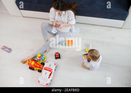 Une jeune femme ignore son enfant et regarde son mobile téléphones Banque D'Images