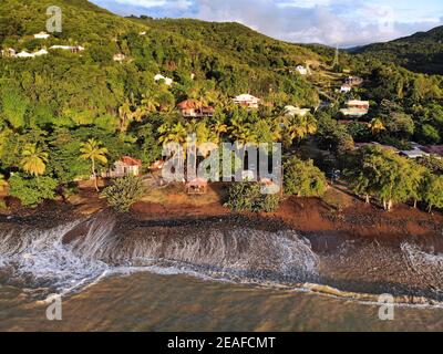 Guadeloupe plage vue sur le coucher du soleil. Plage Caraibe vue aérienne de la plage noire à Pointe Noire. Ombres à vagues de l'océan rétroéclairées. Banque D'Images