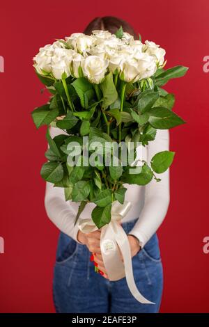 La fille avec grand bouquet de roses blanches à l'avant d'elle Banque D'Images