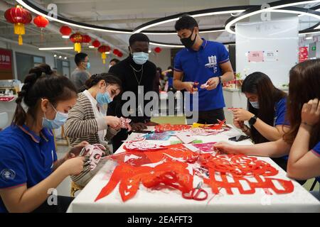 (210209) -- BEIJING, 9 février 2021 (Xinhua) -- les étudiants étrangers essaient de couper le papier traditionnel chinois à l'Université Jiaotong de Beijing, capitale de la Chine, le 8 février 2021. Tenant compte de l'appel de l'État pour rester mis pour le prochain Festival de printemps, ou le nouvel an lunaire chinois, comme mesure de prévention et de contrôle de COVID-19, plus de 1,000 étudiants et facultés de l'Université de Beijing Jiaotong ont choisi de passer leur séjour sur le campus. Plus de 700 membres du personnel de restauration, de sécurité, d'alimentation et de services médicaux de l'université ont également collé à leurs postes pour que ces étudiants un Banque D'Images