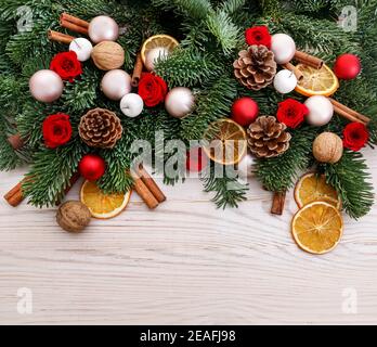 Décoration de Noël avec roses rouges, sapin, oranges, cônes et bâtons de cannelle. Fête Banque D'Images