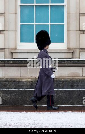 Londres, Royaume-Uni. 9 février 2021. Météo au Royaume-Uni : un membre de la garde de la Reine en service de garde à l'extérieur de Buckingham Palace lors de légères averses de neige tandis que le temps froid provoqué par Storm Darcy continue. Credit: Stephen Chung / Alamy Live News Banque D'Images