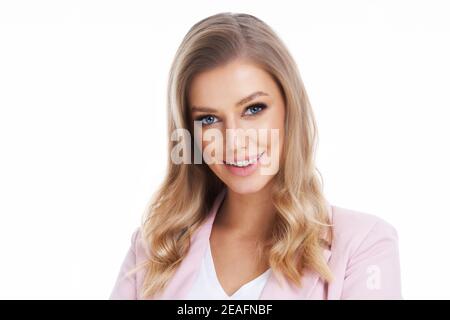 Femme blonde en costume pastel posant sur fond blanc Banque D'Images