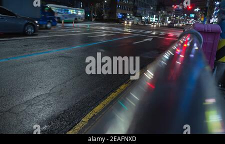 Photo de ville de nuit avec flèches de marquage routier et rails en métal brillant. Résumé historique du transport urbain Banque D'Images