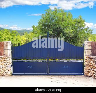 Porte en fer forgé et pilier en pierre isolés sur fond blanc. Banque D'Images