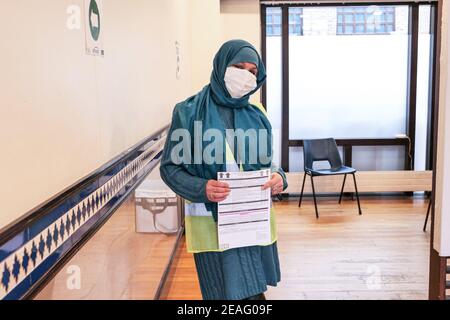 Londres Royaume-Uni - 07 février 2021 : une femme quelques instants avant de se faire vacciner dans le nouveau centre de vaccination Covid-19 reconverti Al-Manaar à Londres Banque D'Images