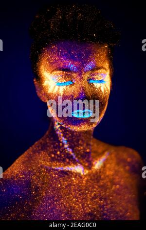 portrait uv en gros plan lumineux dans un modèle femelle sombre Banque D'Images
