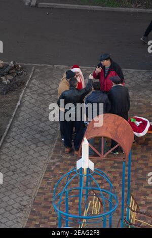 Tiraspol, Moldova - 1er janvier 2021 : un homme habillé comme le Père Noël et un groupe d'hommes qui boivent de l'alcool sur l'aire de jeux le premier jour du nouvel an 2 Banque D'Images