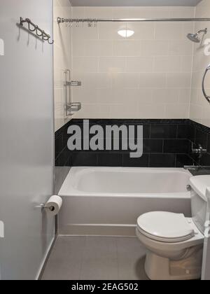 Intérieur de la salle de bains de l'appartement avec carrelage, baignoire, toilettes et douche Banque D'Images