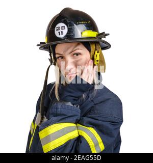 jeune femme en uniforme de pompier et de casque de sécurité touchant le visage à la main Banque D'Images