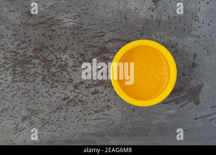 Bol jaune de sirop de maïs léger décalé sur fond gris éclairé par un éclairage naturel. Banque D'Images