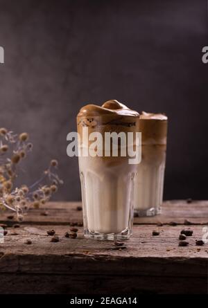 Café Dalgona. Boisson fouettée à glacer avec café instantané populaire en Corée cocktail crémeux dans de grands verres. Photographie de nourriture sombre Banque D'Images