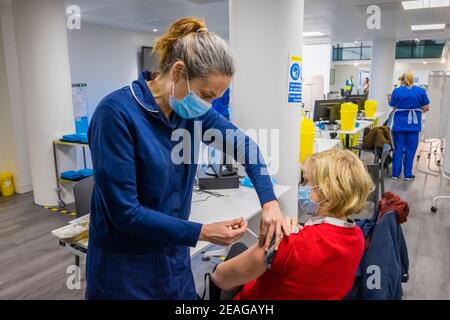 Une femme locale reçoit son injection de vaccin COVID-19 Pfizer d'une infirmière du site de vaccination Covid-19 à Woking, Surrey, dans le sud-est de l'Angleterre Banque D'Images