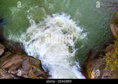 Vue aérienne de la cascade de la rivière avec de l'eau turquoise claire tombant entre des blocs mouillés avec de la mousse blanche épaisse. Banque D'Images