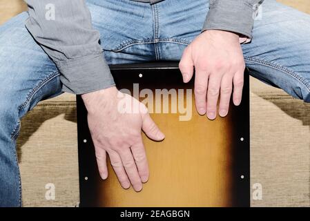 L'homme joue le tambour de cajon. Vue rapprochée des mains du batteur lors de la pratique de l'instrument à percussion. Banque D'Images