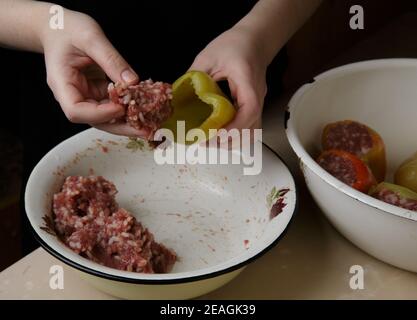 les mains du chef remplissent les poivrons de viande hachés viande Banque D'Images