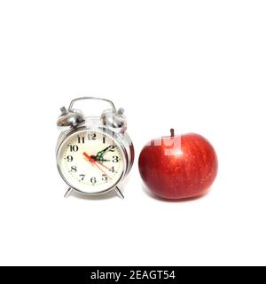 Pomme rouge et horloge isolée sur fond blanc, concept de temps Banque D'Images