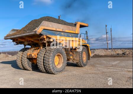 Tombereau à benne basculante chargé de minerai. Transport du minerai extrait de la fosse ouverte à la surface Banque D'Images