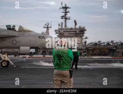 Photo de Matt Gibson, chef mécanicien de charpente aéronautique de la Marine américaine, chef de la petite section des « Golden Warriors » du Strike Fighter Squadron (VFA) 87, regarde un F/A-18e Super Hornet, affecté au VFA-87, se préparer au lancement à partir du pont de vol USS Theodore Roosevelt (CVN 71) Dans le cadre d'opérations à deux transporteurs avec le Nimitz Carrier Strike Group en mer de Chine méridionale le 9 février 2021. Deux groupes de grève des porte-avions de la Marine américaine ont commencé leurs opérations dans les eaux contestées de la mer de Chine méridionale mardi, le dernier spectacle des capacités navales de l'administr Biden Banque D'Images