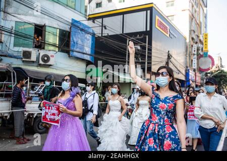 Yangon, Myanmar. 10 février 2021. Les manifestants portant des robes de mariée marchent dans la rue pendant la manifestation. Des milliers de personnes sont descendues dans les rues de Yangon le cinquième jour de protestation contre le coup d'État militaire et ont demandé la libération d'Aung San Suu Kyi. L'armée du Myanmar a arrêté le conseiller d'État du Myanmar Aung San Suu Kyi le 01 février 2021 et a déclaré l'état d'urgence tout en prenant le pouvoir dans le pays pendant un an après avoir perdu les élections contre la Ligue nationale pour la démocratie (NLD). Crédit : SOPA Images Limited/Alamy Live News Banque D'Images