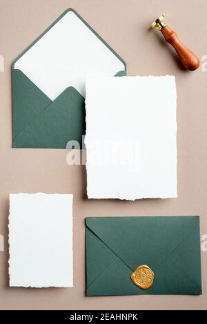 Cartes d'invitation de mariage, maquettes, enveloppes vertes et cachet de cire vue du dessus. Élégante papeterie de mariage. Banque D'Images