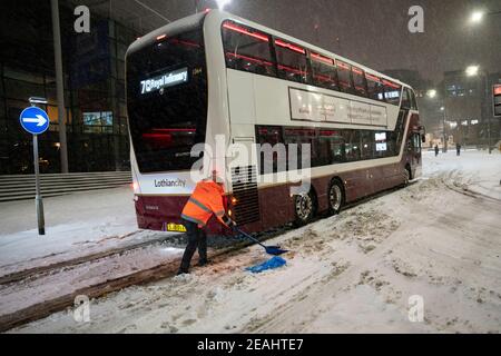 Édimbourg, Écosse, Royaume-Uni. 10 févr. 2021. Le gros gel se poursuit au Royaume-Uni avec de la neige abondante de nuit et du matin, ce qui immobilise la circulation sur de nombreuses routes du centre-ville. Pic ; les bus Lothian sont bloqués sur Leith Walk à 6h du matin. Iain Masterton/Alamy Live News Banque D'Images