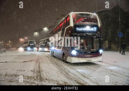 Édimbourg, Écosse, Royaume-Uni. 10 févr. 2021. Le gros gel se poursuit au Royaume-Uni avec de la neige abondante de nuit et du matin, ce qui immobilise la circulation sur de nombreuses routes du centre-ville. Pic ; les bus Lothian luttent sur Leith Walk à 6h du matin. Iain Masterton/Alamy Live News Banque D'Images