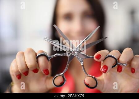 Coiffeur tient des ciseaux de travail avec le peigne dans ses mains Banque D'Images