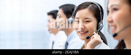 Souriante belle femme asiatique agent de télémarketing travaillant avec l'équipe dans arrière-plan de la bannière du bureau du centre d'appels avec espace de copie Banque D'Images