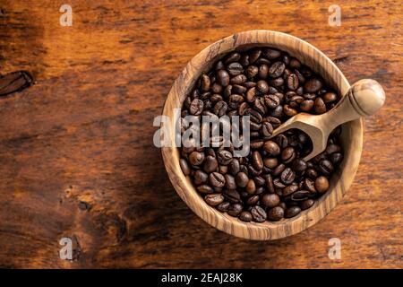 Grains de café rôtis dans un bol en bois Banque D'Images