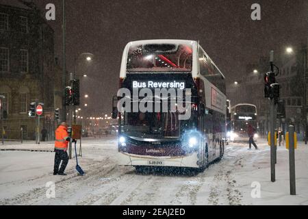 Édimbourg, Écosse, Royaume-Uni. 10 févr. 2021. Le gros gel se poursuit au Royaume-Uni avec de la neige abondante de nuit et du matin, ce qui immobilise la circulation sur de nombreuses routes du centre-ville. Pic ; les bus Lothian sont bloqués sur Leith Walk à 6h du matin. Iain Masterton/Alamy Live News Banque D'Images