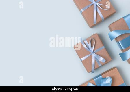 Groupe de boîtes-cadeaux sur fond bleu. Présenter avec ruban attaché. Concept festif avec espace publicitaire. Banque D'Images