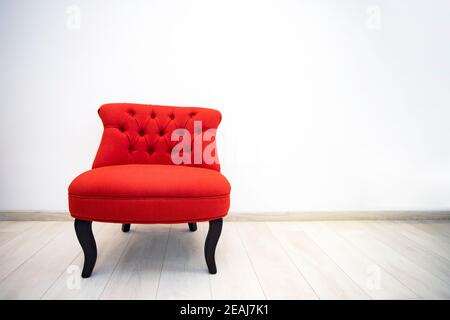 Fauteuil rouge antique dans une chambre blanche Banque D'Images