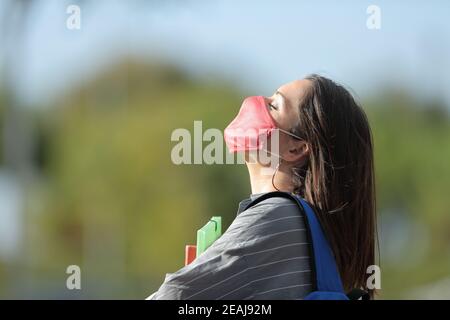 Étudiant avec masque respirant de l'air frais dans un parc Banque D'Images