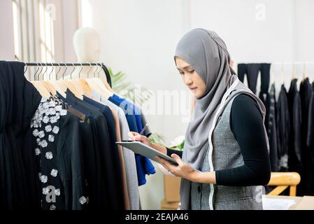 Femme musulmane asiatique designer en tant que startup propriétaire d'entreprise travaillant dans sa boutique de tailleur Banque D'Images