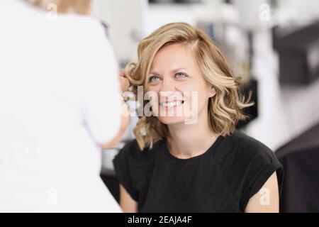 Portrait d'une femme souriante qui a fait ses cheveux boucles Banque D'Images