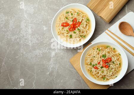 Concept de manger savoureux avec des bols de nouilles sur le gris arrière-plan Banque D'Images