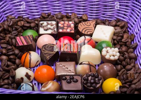 divers pralines au chocolat et grains de café dans un panier à lavande Banque D'Images