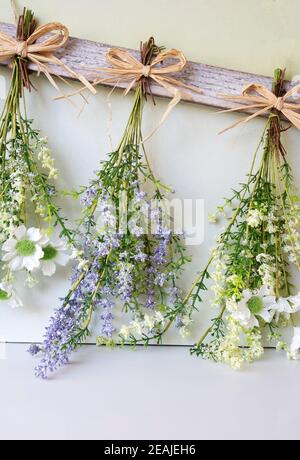Divers bouquet lumineux de fleurs séchées accrochées à la corde sur fond de bois, faisant des fleurs séchées décoration moderne pour l'intérieur de la maison Banque D'Images