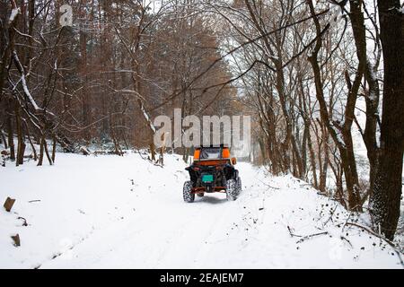 Les gens qui apprécient leur week-end dans un buggy tout-terrain sur un sentier d'hiver Banque D'Images