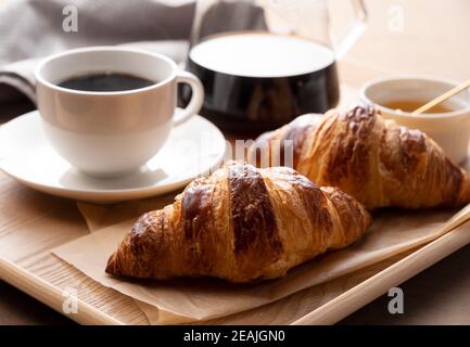 Croissants et café sur un plateau en bois Banque D'Images