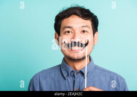 beau homme portant une carte de moustache drôle sur sa bouche Banque D'Images