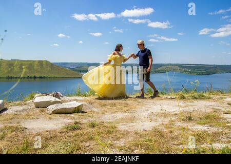 Un jeune couple dansant sur une falaise au bord de la baie Banque D'Images