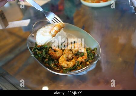 Crevettes ou crevettes frites avec feuilles de basilic, œuf frit sur le riz. Cuisine thaïlandaise Banque D'Images