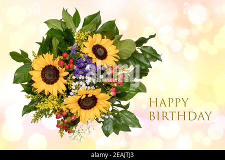 Carte d'anniversaire avec un magnifique bouquet de tournesols fleuris sur un arrière-plan flou pastel délicat et abstrait. Banque D'Images