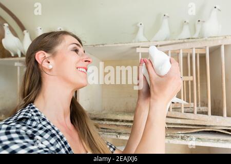 Femme avec colombe dans le loft pigeon Banque D'Images