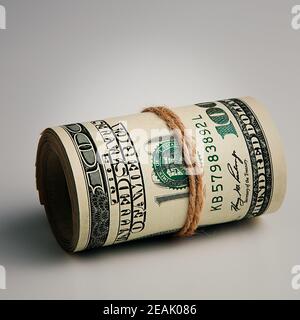 Rouleau d'un gros plan de cent dollars américains sur fond gris. Banque D'Images
