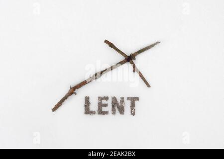 Concept pour la saison de Carême. Croix de bois ou crucifix et texte fait de cendres sur fond de neige. Banque D'Images