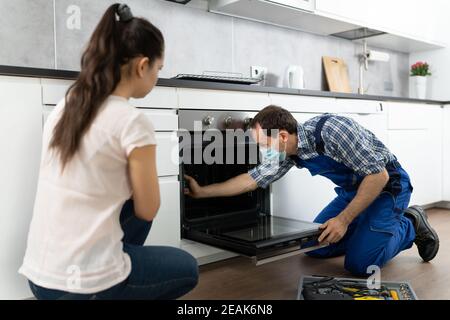 Réparation de four d'appareil de cuisine par un technicien Handyman Banque D'Images